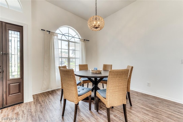 dining space with light wood-style floors, baseboards, and a chandelier