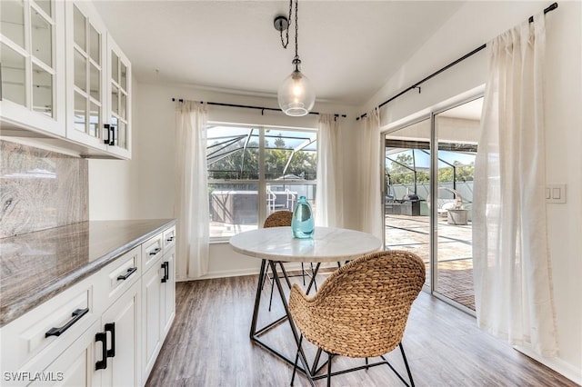 dining room with light wood-type flooring and a sunroom