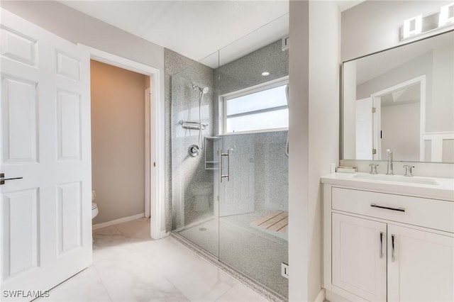 bathroom featuring a shower stall, toilet, vanity, and baseboards