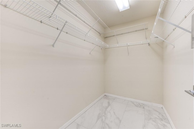 spacious closet featuring marble finish floor