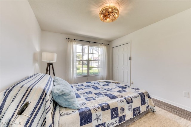 bedroom featuring a closet, baseboards, and wood finished floors