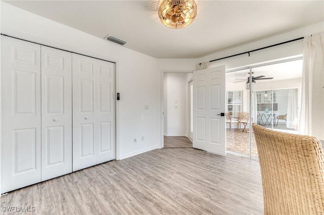 unfurnished bedroom with light wood finished floors, visible vents, a closet, and baseboards