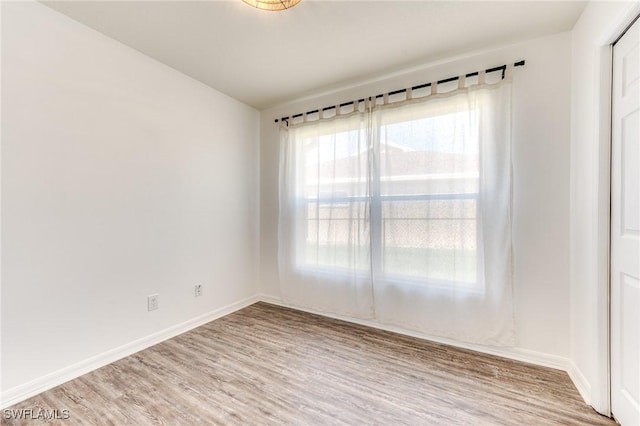 spare room featuring wood finished floors and baseboards