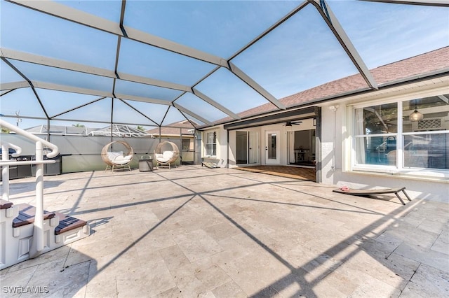 rear view of house featuring glass enclosure and a patio area