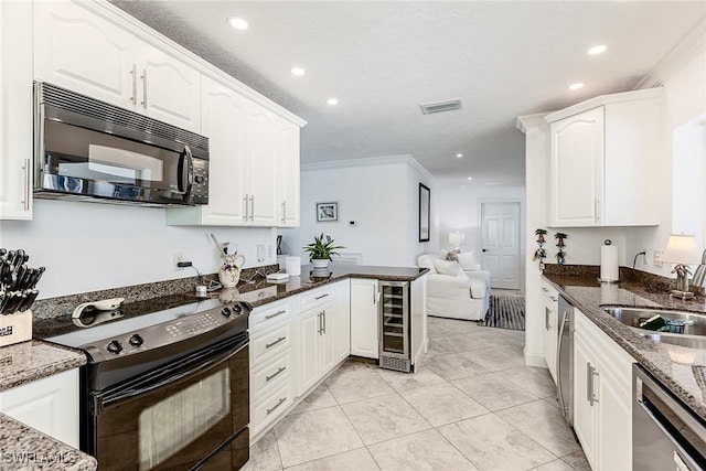 kitchen with visible vents, a sink, black appliances, wine cooler, and white cabinets