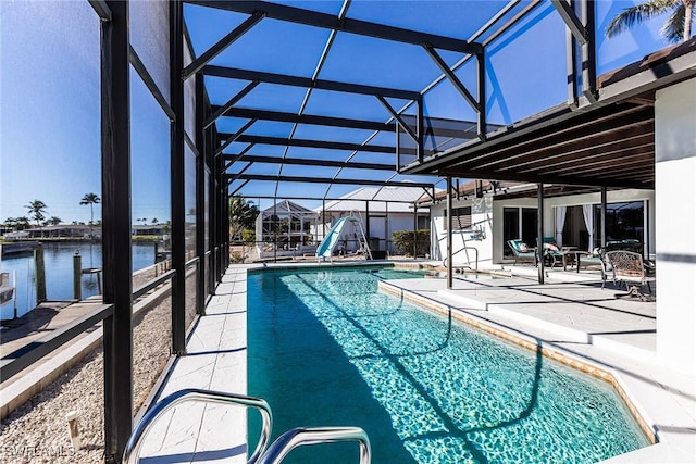 pool featuring glass enclosure, a patio, and a water view