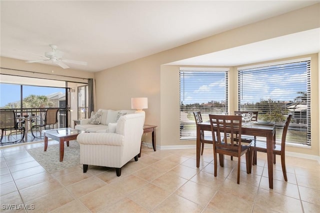 dining space featuring baseboards, a ceiling fan, and light tile patterned floors