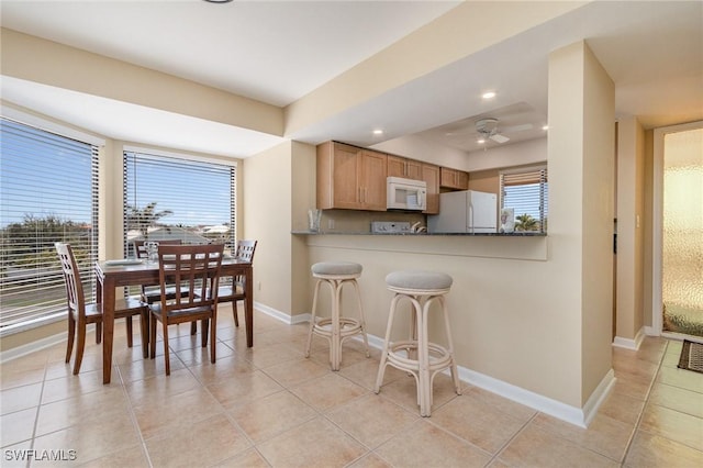 kitchen featuring baseboards, light tile patterned floors, white appliances, ceiling fan, and recessed lighting