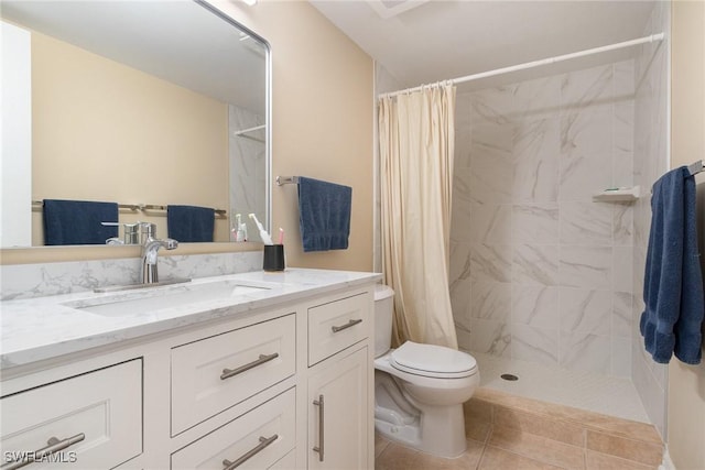 full bath featuring a tile shower, toilet, tile patterned floors, and vanity