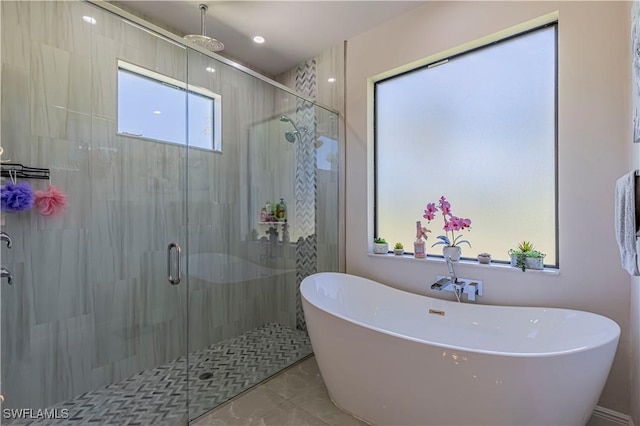 bathroom featuring a freestanding tub and a shower stall