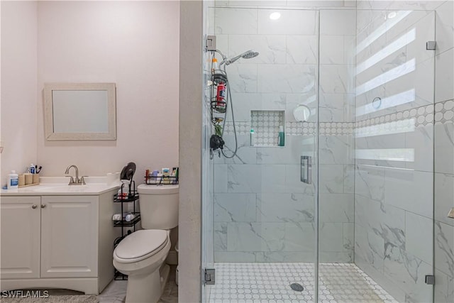 full bath featuring a stall shower, toilet, and vanity