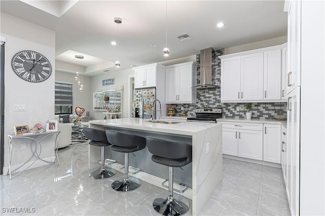 kitchen featuring visible vents, marble finish floor, a sink, appliances with stainless steel finishes, and wall chimney exhaust hood