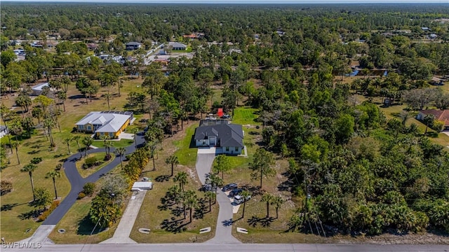 birds eye view of property featuring a forest view