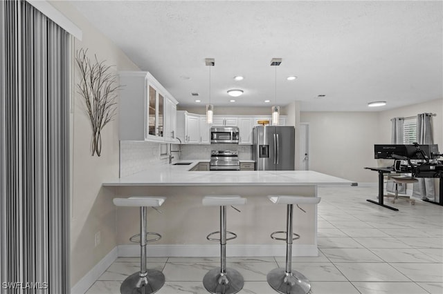 kitchen featuring a sink, glass insert cabinets, appliances with stainless steel finishes, and light countertops