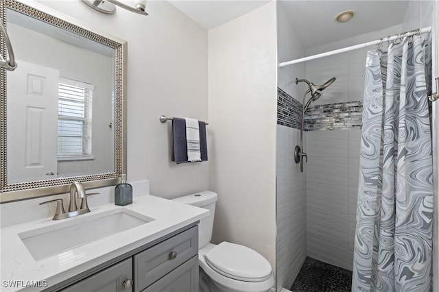 full bath featuring toilet, vanity, and a tile shower