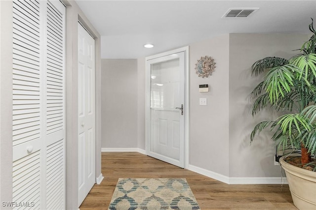 foyer featuring recessed lighting, visible vents, baseboards, and wood finished floors