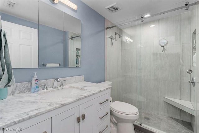 bathroom featuring vanity, toilet, visible vents, and a stall shower