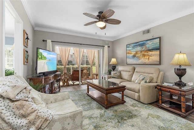 living area featuring visible vents, crown molding, ceiling fan, and wood finished floors