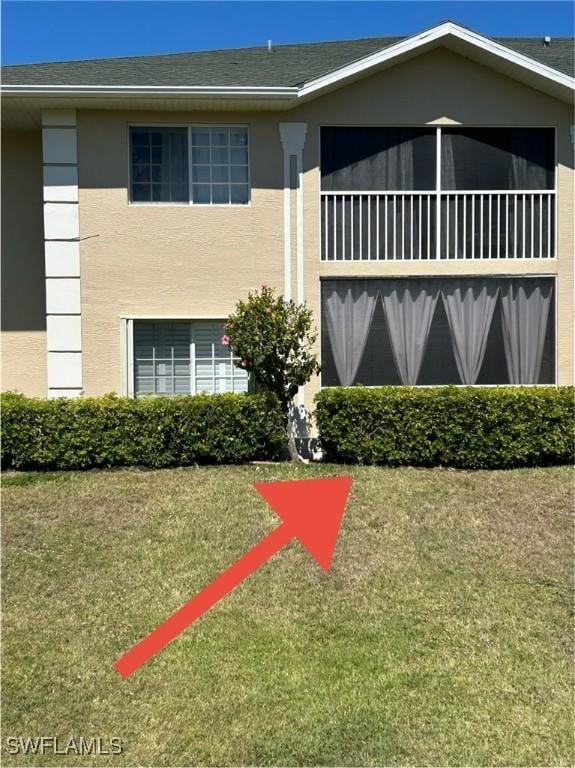 view of front facade featuring a front lawn and stucco siding