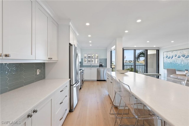 kitchen featuring light countertops, white cabinets, backsplash, and appliances with stainless steel finishes