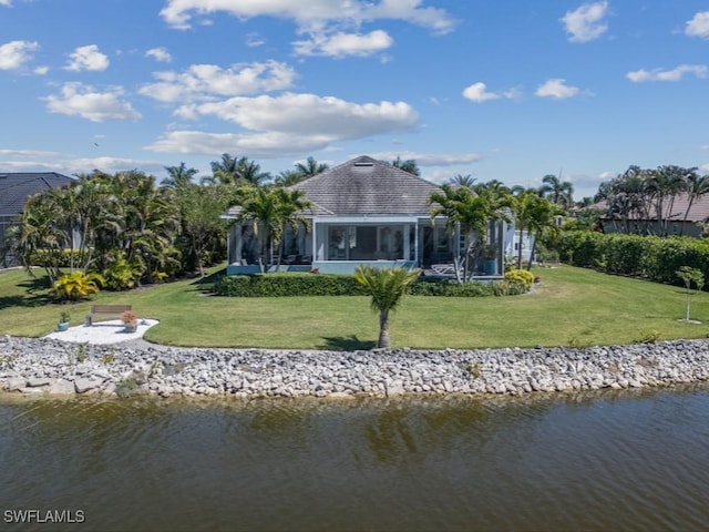 back of house with a yard and a water view