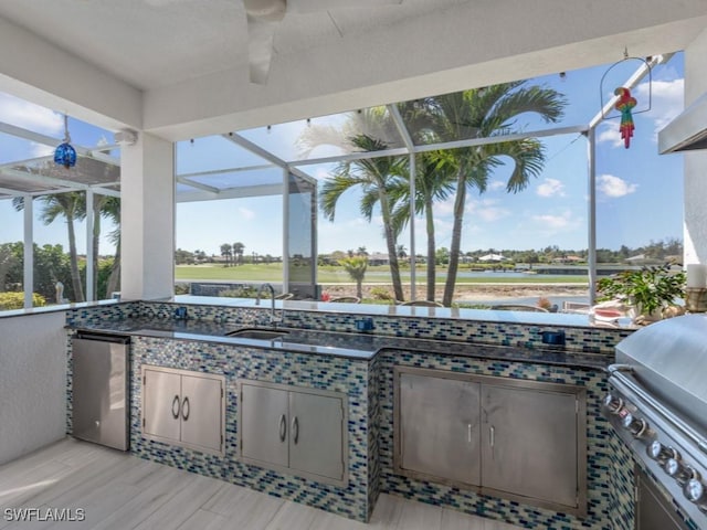 view of patio with a lanai, grilling area, an outdoor kitchen, and a sink