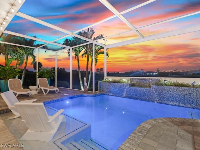 pool at dusk featuring a patio, an outdoor pool, and a lanai