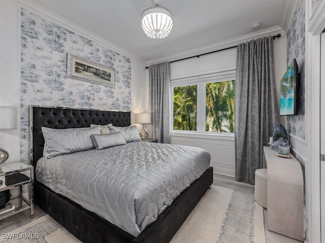 bedroom with wallpapered walls, a chandelier, and ornamental molding