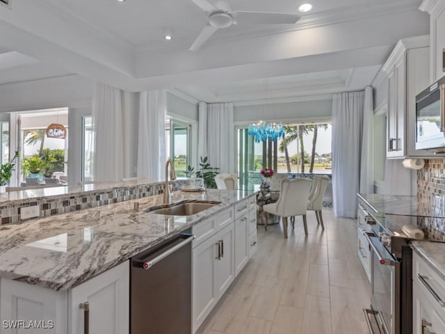 kitchen with a sink, decorative backsplash, plenty of natural light, and appliances with stainless steel finishes