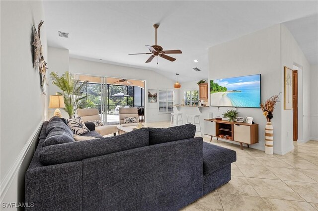 living room with vaulted ceiling, light tile patterned flooring, visible vents, and ceiling fan