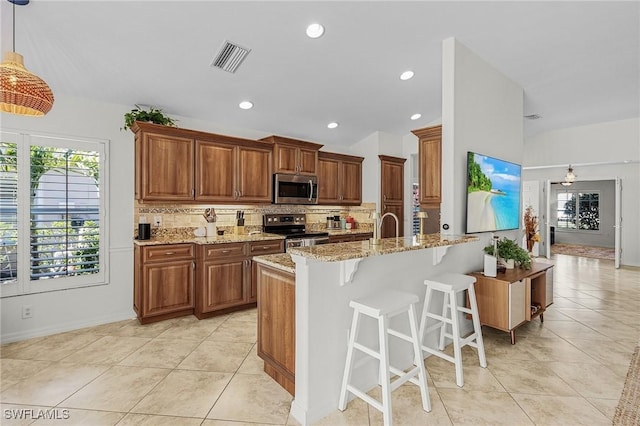 kitchen with vaulted ceiling, visible vents, backsplash, and stainless steel appliances