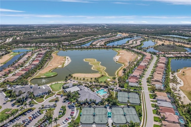 drone / aerial view with golf course view and a water view