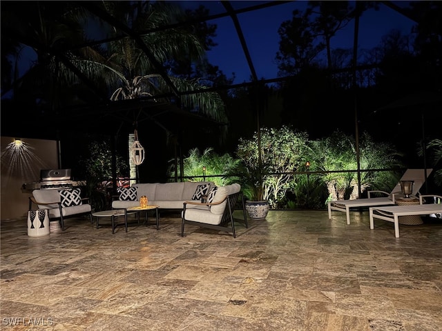 patio at night with outdoor lounge area and a lanai