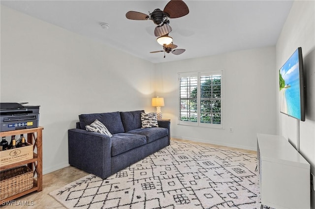 living room with baseboards and a ceiling fan