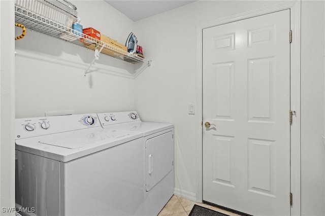 laundry area with washing machine and clothes dryer, laundry area, and light tile patterned flooring