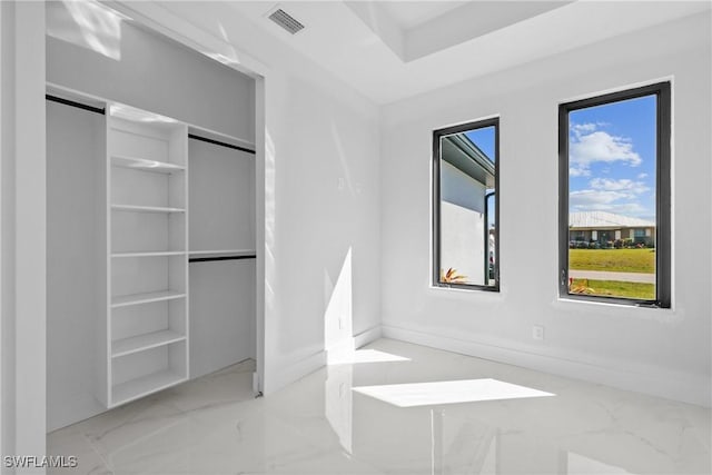 unfurnished bedroom with a closet, visible vents, and marble finish floor