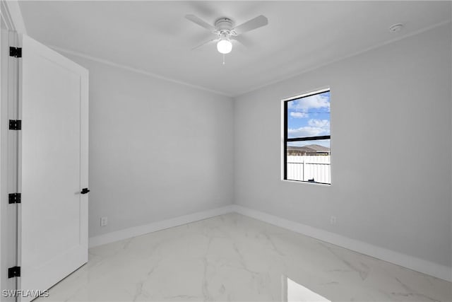 spare room featuring a ceiling fan, baseboards, and marble finish floor