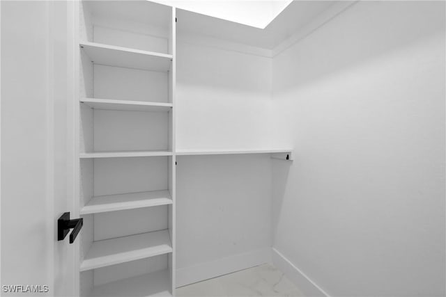 spacious closet featuring marble finish floor