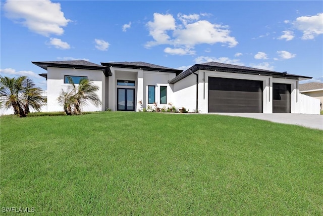 prairie-style house featuring a front yard, a garage, driveway, and stucco siding