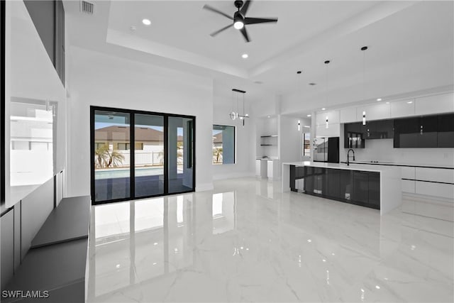 kitchen featuring a raised ceiling, white cabinets, modern cabinets, and visible vents