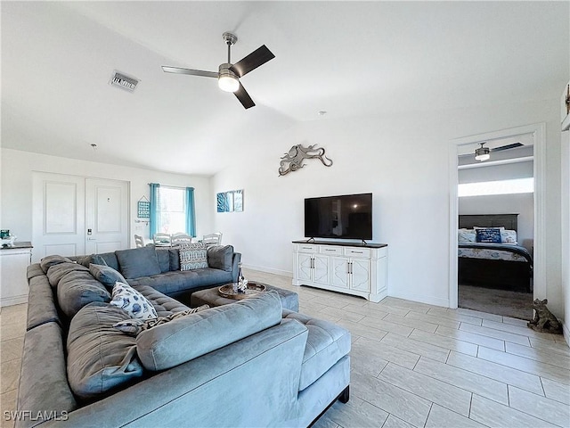 living area with visible vents, baseboards, lofted ceiling, and a ceiling fan