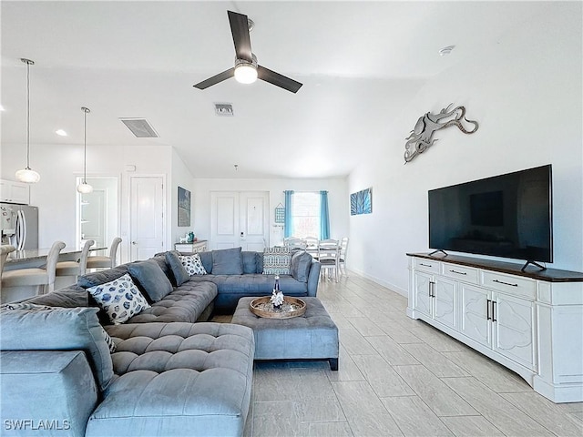 living room with wood finish floors, visible vents, baseboards, and a ceiling fan