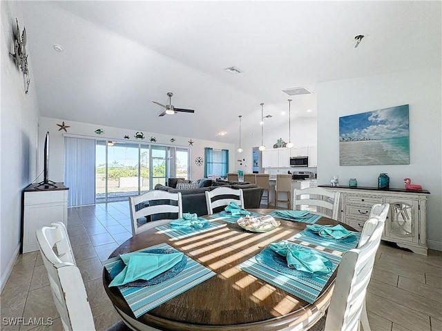 dining room featuring baseboards, lofted ceiling, visible vents, and ceiling fan