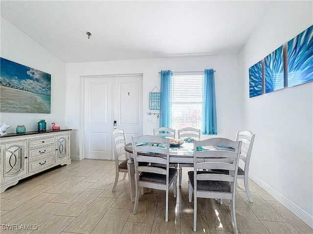 dining space with baseboards and wood finish floors