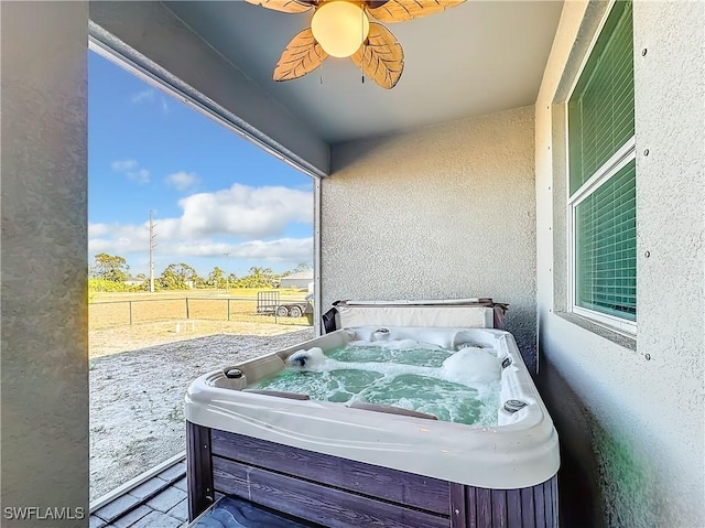 view of patio / terrace with a hot tub and fence