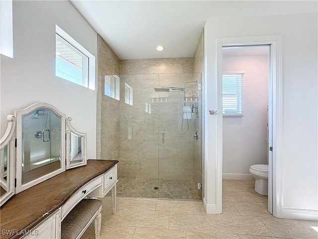 full bathroom featuring a shower stall, toilet, a healthy amount of sunlight, and baseboards