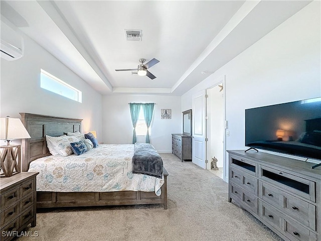 bedroom featuring a wall mounted air conditioner, visible vents, light carpet, a tray ceiling, and baseboards