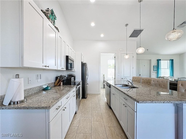 kitchen featuring visible vents, a spacious island, a sink, stainless steel appliances, and white cabinetry