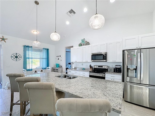 kitchen with a breakfast bar, visible vents, stainless steel appliances, and a sink