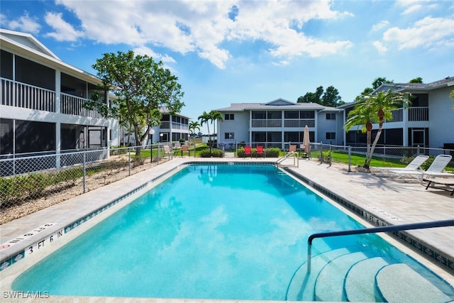 community pool featuring a patio and fence